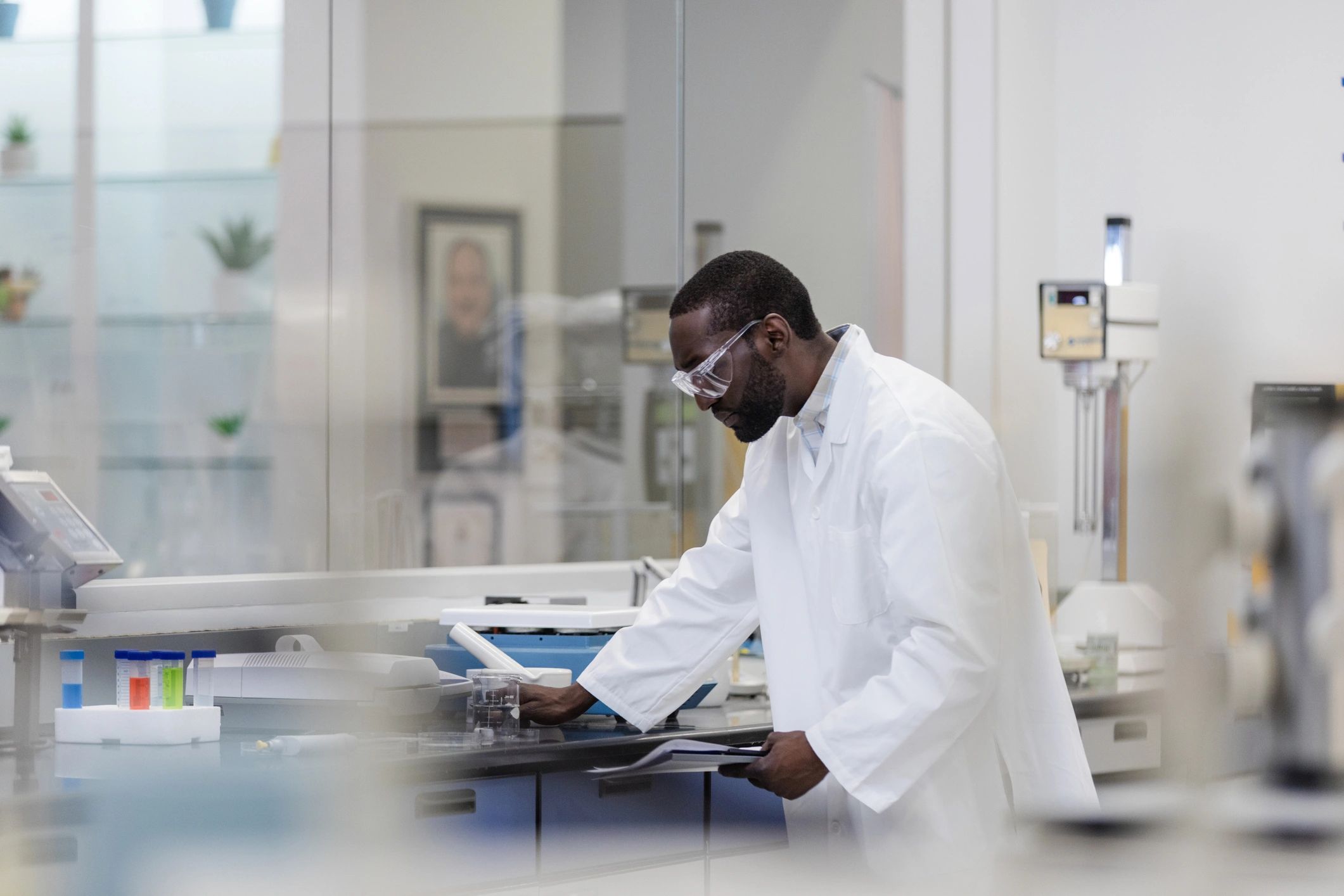 Lab professional reviewing notes while working at a laboratory bench