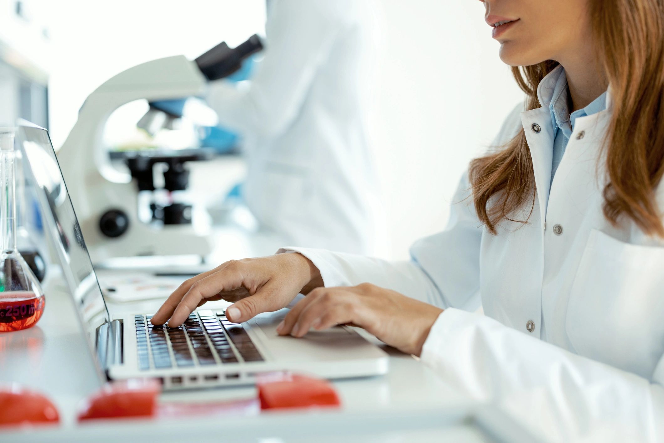 Scientist reviewing research data on a laptop in a modern laboratory